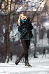 Pportrait of young attractive blonde girl smiling in winter park