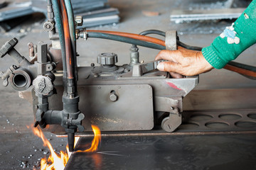 Man cutting gas cutting steel with sparks.