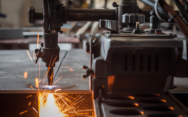 Gas cutters cutting steel with sparks.