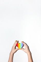 Rainbow painted craft heart in hands for lesbian, gay, bisexual, transgender flag