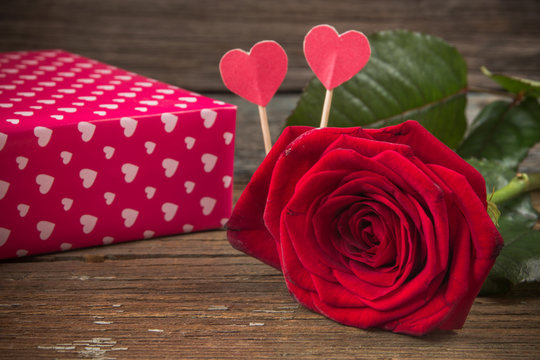Red rose and gift box on a old wooden table
