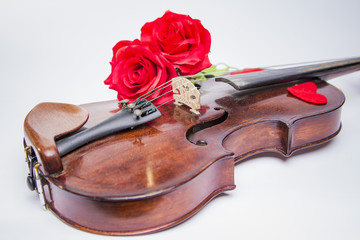 Obraz premium Valentine's Day: Romantic old violin with heart shapes and red rose on white background