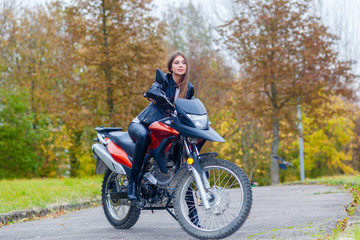 Naklejka na ściany i meble Portrait of a beautiful hipster girl on a sports motorcycle