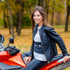 Fototapeta na wymiar Portrait of a beautiful hipster girl on a sports motorcycle