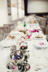 Elegant orchid stands in vase on white dinner table