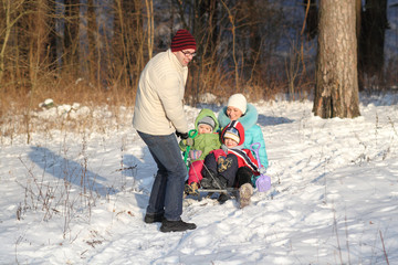 Fototapeta na wymiar family of four has fun in the snow in winter
