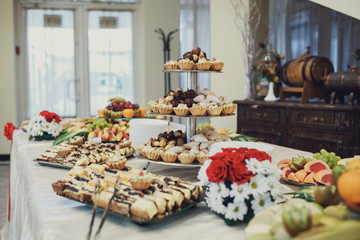 Sweet baked basckets with cream and pieces of cakes served on ti