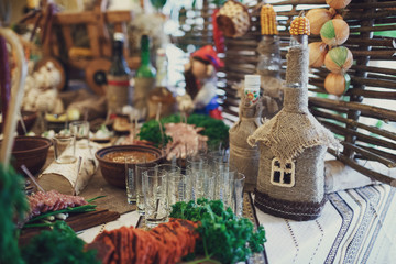 Bottles in form of little houses stand on table with snacks