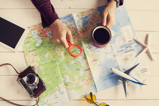 Young man planning vacation trip with map