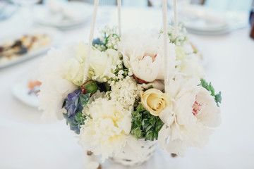 Bouquet of white roses and peonies put in a bascket