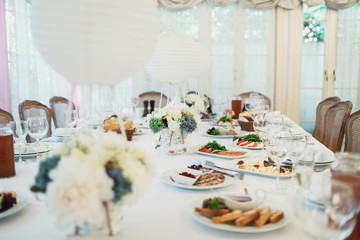 Decorative balloons with flowers in basckets stand on dinner tab