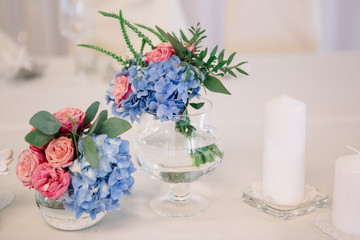 Little glass bowls with pink roses and blue hydrangeas
