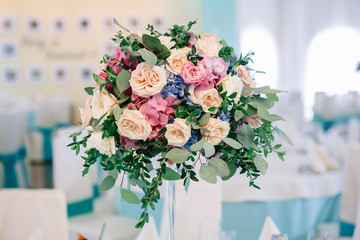 Glass centerpiece of beige roses and pink hydrangeas