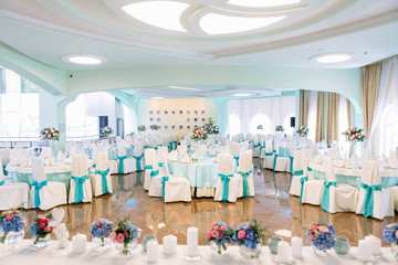 Look from behind dinner table with flowers at restaurant's hall