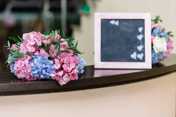 Little bouquets of pink and blue hydrangeas lie around white fra