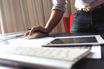 Male manager putting his ideas and writing business plan at workplace with warm fall colors. soft-focus in the background. over light