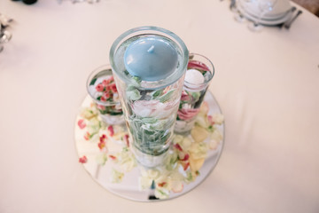 Look from above at little blue candle on the top of water with r