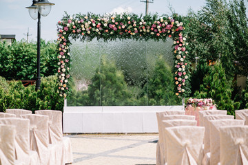 Glass wall with shower and decorated with garland of roses make