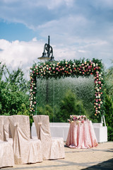Glass wall with shower and decorated with garland of roses make