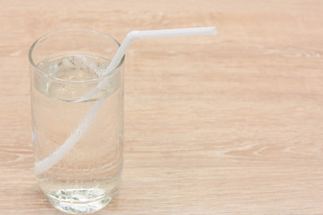 Water glass on wood background.