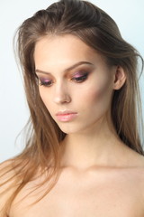 Fototapeta premium Closeup studio portrait of young beautiful model with professional makeup. Beautiful face of young adult woman