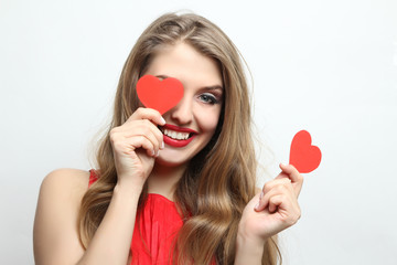 Happy girl close one eye with red decorative heart.