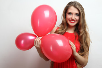 Cheerful girl holding balloons in hands.