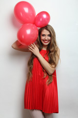 Cheerful girl holding balloons in hands.