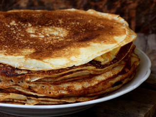 Fried crepes on the plate. Russian pancakes. View from side. Selective focus
