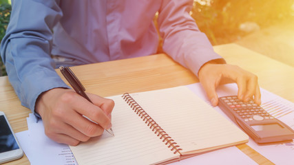 Closeup of hand man using calculator and calculate about cost at home office.
