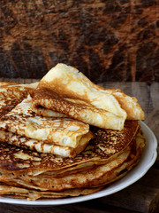 Fried crepes on the plate. Russian pancakes. View from side. Selective focus
