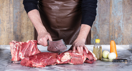 hand butcher cuts a large piece of meat