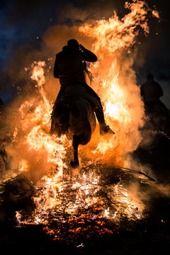 Fototapeta Man riding horse through a bonfire