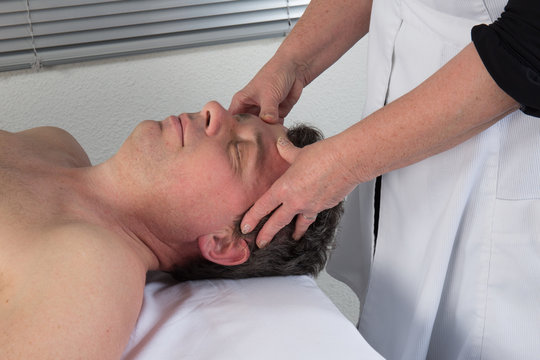 A therapist using acupressure to cure a man