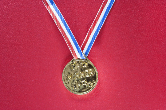 Gold medal on a red background. Winning and achievement concept
