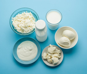 Protein products: cheese, cream, milk, eggs on the blue backgrou