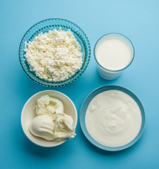 Protein products: cheese, cream, milk, eggs on the blue backgrou