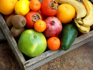 Composition of mix colored tropical and mediterranean fruits on wooden background. Concepts about decoration, healthy eating