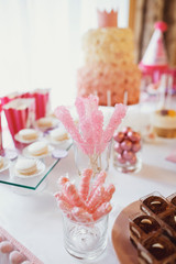 Pink candies on sticks stand in a glass