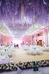 Decorative wave made of white paper and flowers hangs across the