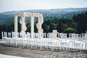 White wedding altar and chairs stand outside somewhere in the mo