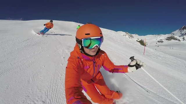 4k skiing footage, selfie perspective woman and two men skiing down ski piste 
