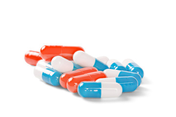 pile of medical pills blue and red color on isolated white background