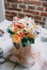 Bouquet of yellow and pink roses stands in white box
