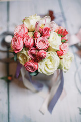 Bouquet of white and pink roses stands on working table