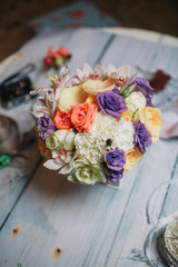 Bouquet of white and violet flowers lies on wooden table