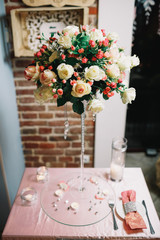 Bouquet of white and pink roses stands on glass plate