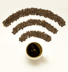 Wi-fi coffee / Creative concept photo of  a cup with coffee beans in the shape of wi-fi sign on white background.