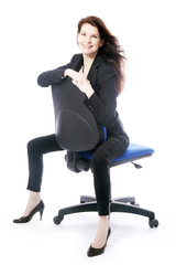 beautiful brunette secretary poses on office chair in studio