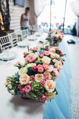 Lots of roses and hydrangeas stand in little wooden boxes on blu